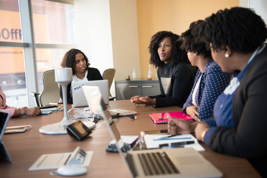 Four women sitting around a conference table in an office.